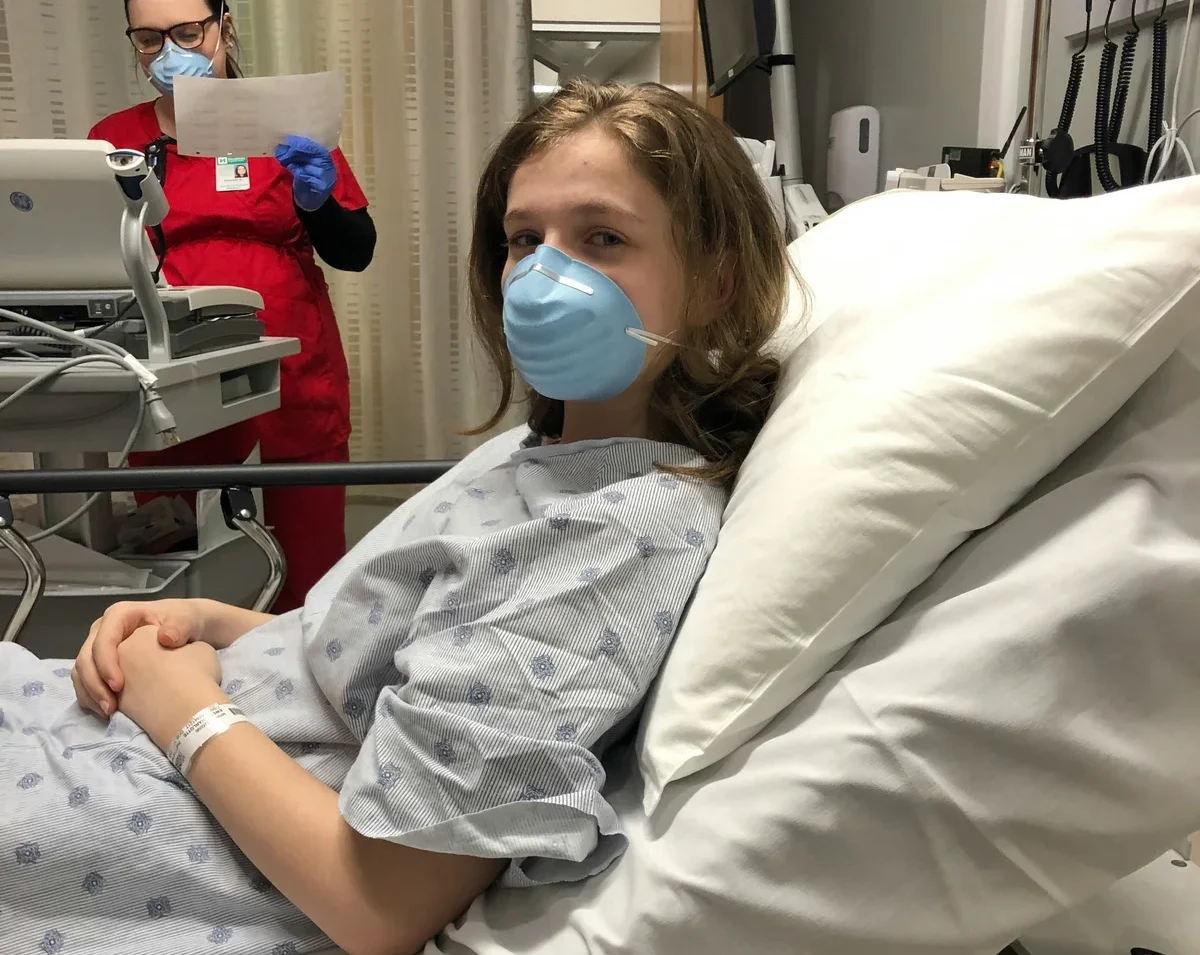 A young girl in a hospital, waiting for her medical appointment
